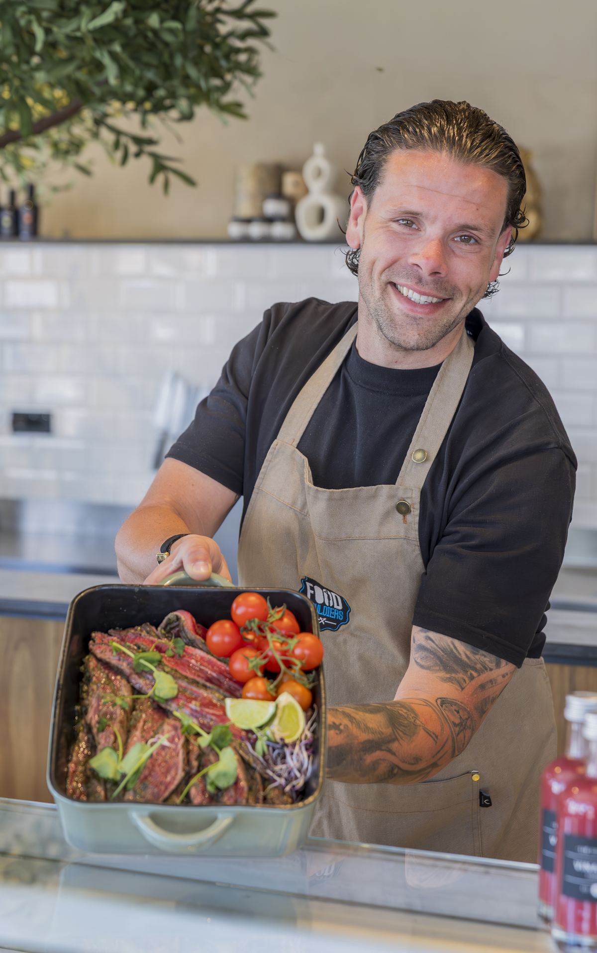 Nils, eigenaar van Foodsouldiers, met een ovenschaal met gemarineerd vlees en tomaatjes