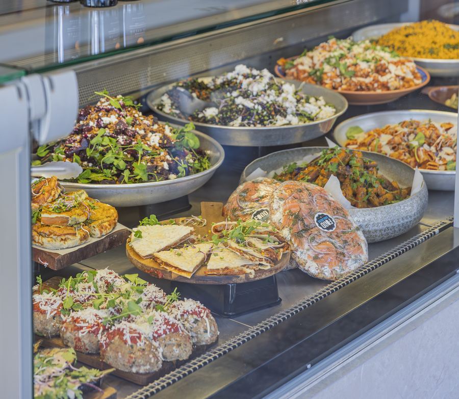 Vitrine van Foodsouldiers met salades, quiches en warme gerechten