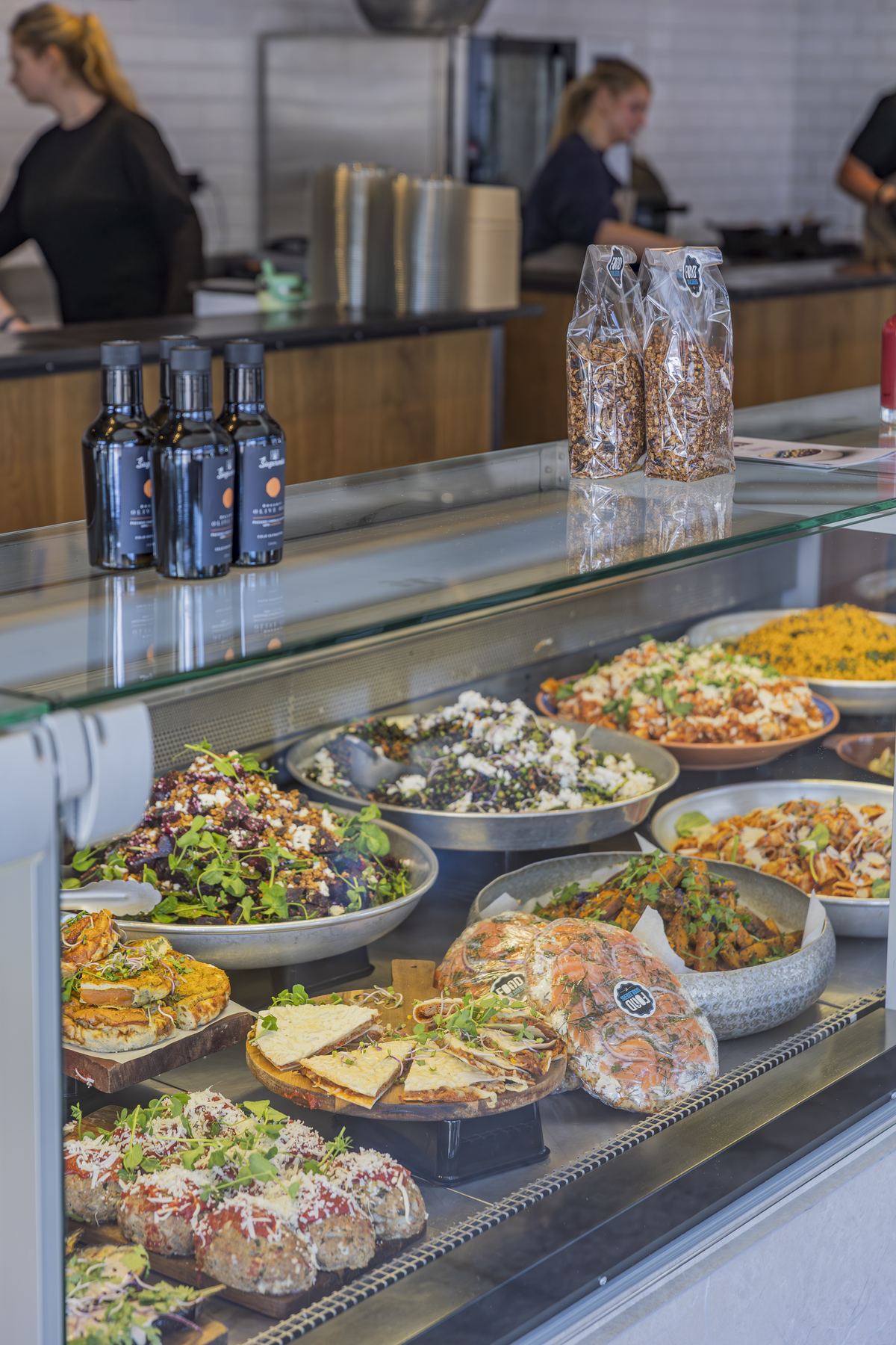 De volle vitrine van de traiteur met salades, quiches en warme gerechten